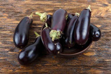 hasat patlıcan bir kil plaka eski koyu ahşap masa. t