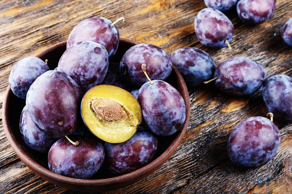 Olgun Erik kahverengi ahşap masa, sağlıklı gıda, yaz kırpma.