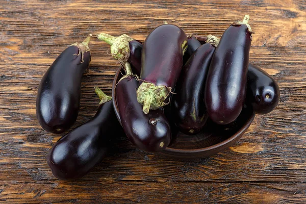 hasat patlıcan bir kil plaka eski koyu ahşap masa. t