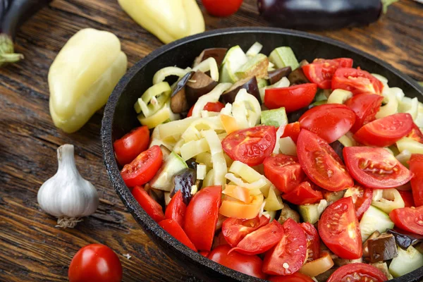 Trancher les légumes frais dans une poêle avec des épices et des ingrédients sur wo — Photo