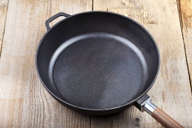 bir dökme demir tava ahşap arka plan üzerinde