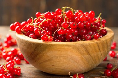 Ahşap bir tabak içinde kırmızı kuş üzümü