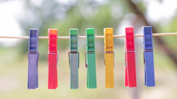 Gekleurde wasknijpers aan een touw — Stockvideo