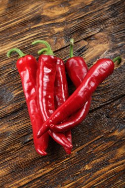 Ahşap bir masa üzerinde kırmızı biber yalan yığını. 