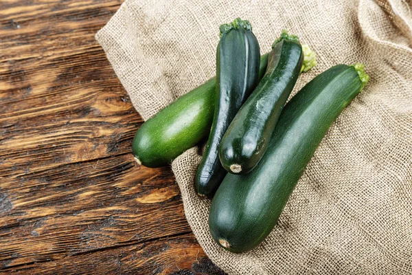 Courgettes fraîches sur un fond en bois brun naturel . — Photo