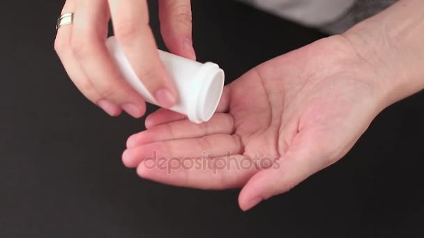 pilules versées dans une main à partir d'un pot 