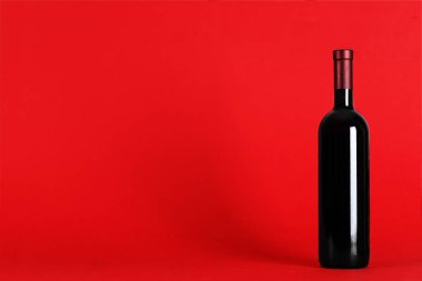 metin için yer ile kırmızı bir arka plan üzerinde şarap şişesi. Üstten Görünüm