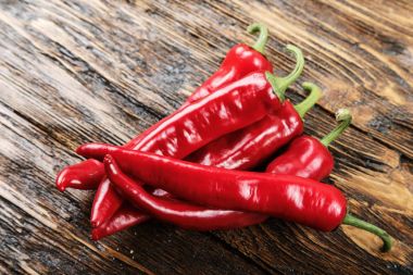 Ahşap bir masa üzerinde kırmızı biber yalan yığını. 