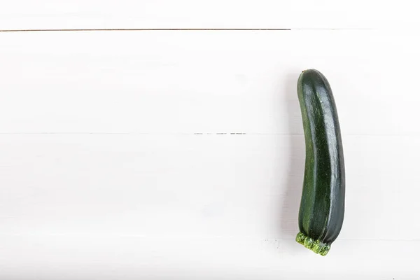 A fresh zucchini on a natural white wooden background. Zucchini — Stock Photo, Image