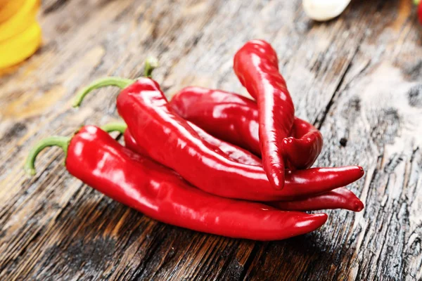 Ahşap bir masa üzerinde kırmızı biber yalan yığını. 