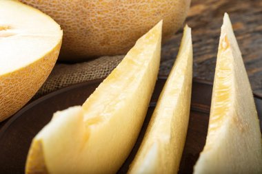 Ahşap masanın üzerine dilimler halinde kesip sulu olgunlaşmış kavun