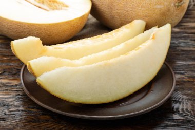 Ahşap masanın üzerine dilimler halinde kesip sulu olgunlaşmış kavun