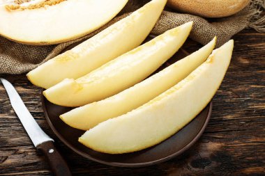 Ahşap masanın üzerine dilimler halinde kesip sulu olgunlaşmış kavun