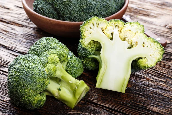 Brokoli di piring tanah liat di atas meja kayu, di samping seluruh kabin — Stok Foto