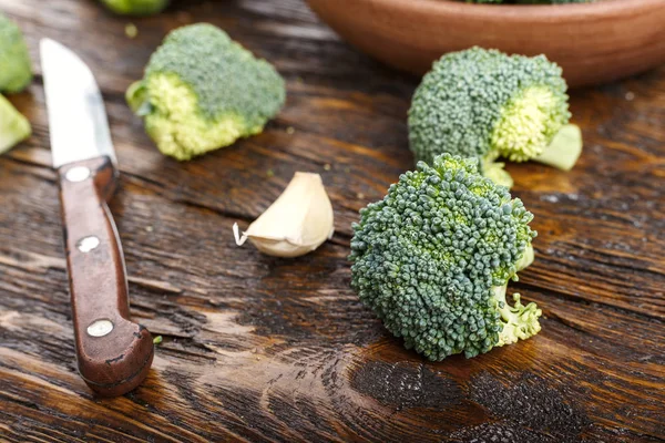 Bütün cabb yanında ahşap bir masa üzerinde bir kil plaka brokoli