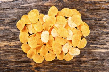 Tahta arka planda patates cipsi.