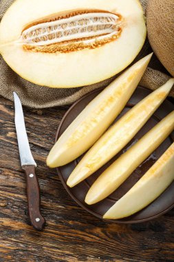 Ahşap masanın üzerine dilimler halinde kesip sulu olgunlaşmış kavun