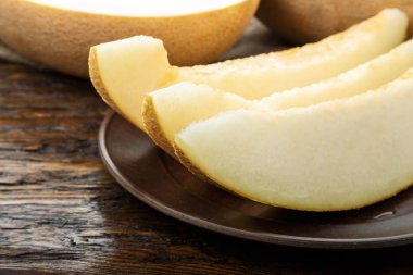 Ahşap masanın üzerine dilimler halinde kesip sulu olgunlaşmış kavun