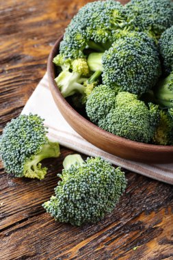 Bütün cabb yanında ahşap bir masa üzerinde bir kil plaka brokoli