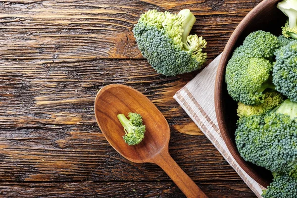 Brokoli di piring tanah liat di atas meja kayu. dengan spasi untuk teks . — Stok Foto