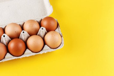 Sarı arka planda tepside tavuk yumurtası.