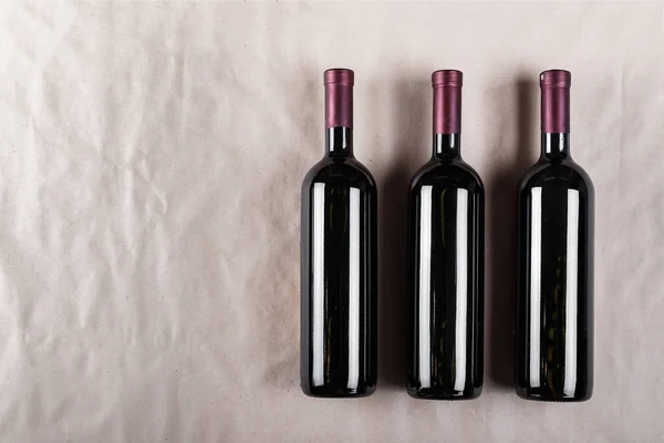 Geschlossene Weinflaschen Auf Dem Hintergrund Von Bastelpapier — Stockfoto