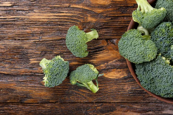 Broccoli i en lera platta på ett träbord, bredvid en hela cabb — Stockfoto