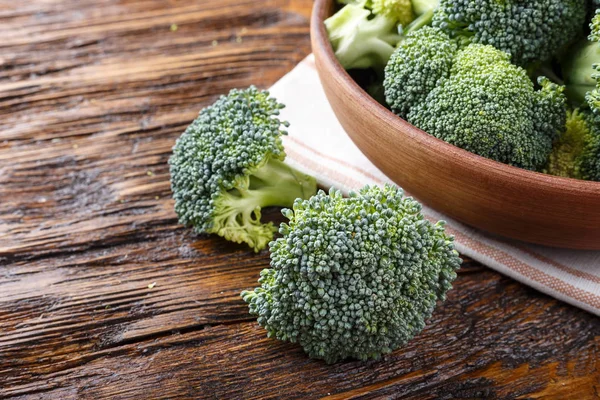 Bütün cabb yanında ahşap bir masa üzerinde bir kil plaka brokoli — Stok fotoğraf