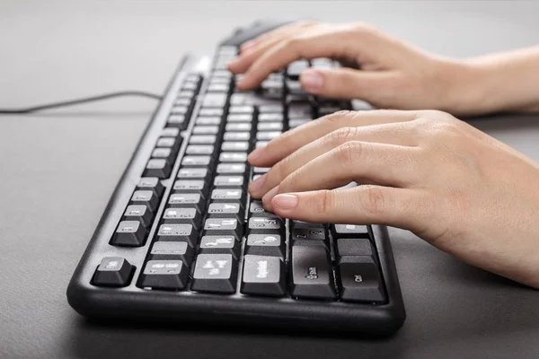 Mãos femininas na vista lateral do teclado — Fotografia de Stock
