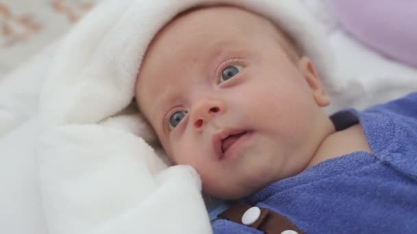 The newborn is awake in the crib — Stock Video