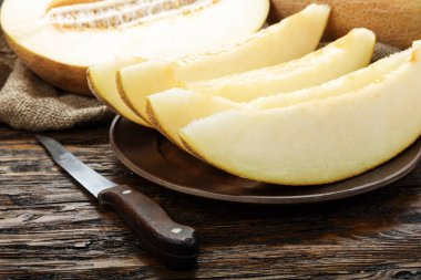 Ahşap masanın üzerine dilimler halinde kesip sulu olgunlaşmış kavun