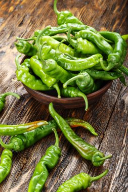 yeşil biber bir kil tabak kahverengi ahşap sekmesinde yerleştirilir