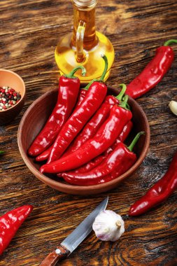 Kırmızı acı biber bir tabak içinde yatıyor. Yakınlarda sarımsak ve orada bir 
