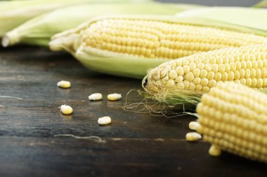 Kırsal ahşap masadaki koçanlarda taze mısır, yakın plan.