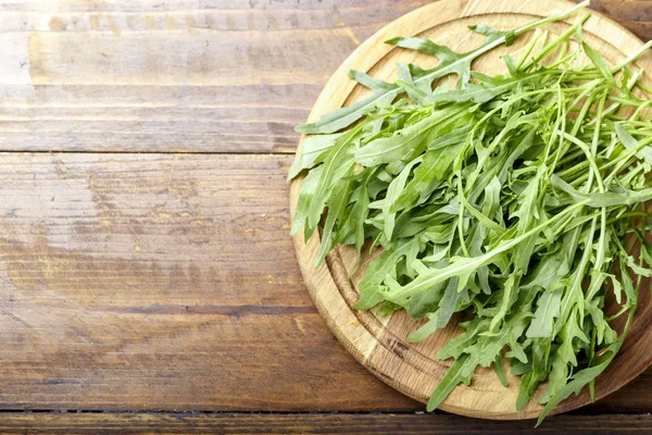 Hojas frescas de rúcula, rúcula, rúcula fresca en un plato, espacio para — Foto de Stock