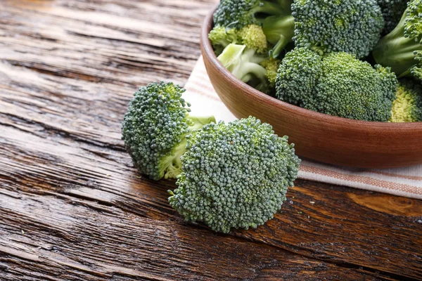 Bütün cabb yanında ahşap bir masa üzerinde bir kil plaka brokoli — Stok fotoğraf
