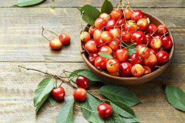 Olgun Kiraz ahşap arka plan üzerinde yaprakları ile