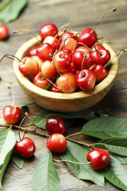 Olgun Kiraz ahşap arka plan üzerinde yaprakları ile