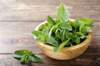 Ahşap arka plan üzerinde bir tabak içinde taze nane