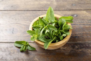 Ahşap arka plan üzerinde bir tabak içinde taze nane