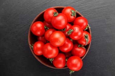 Olgun kırmızı domates siyah bir zemin üzerine bir tabak içinde. Üstten Görünüm