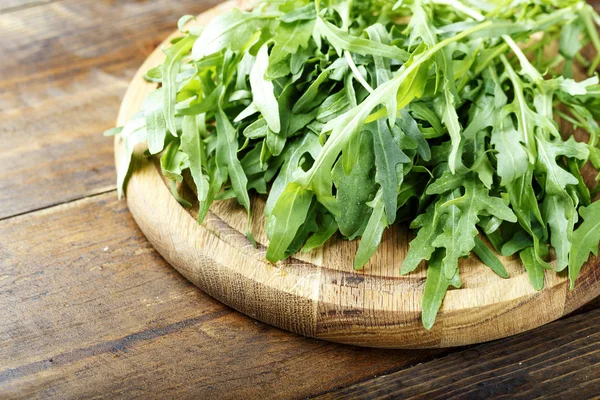 Insalata di rucola su un asse di legno — Foto Stock