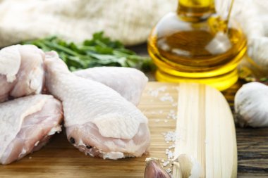 bir kesme tahtası üzerinde çiğ tavuk budu