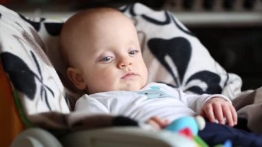 Plastik kemirgenli bebek sandalyede oturuyor..