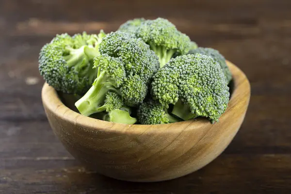 Fresh raw broccoli in a wooden bowl. 