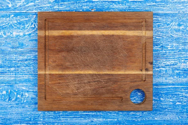 Square cutting board on a blue background. — Stock Photo, Image
