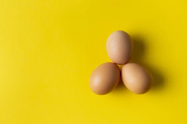 Drie Eieren Gele Achtergrond Uitzicht Van Bovenaf — Stockfoto