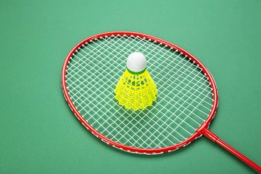 Shuttlecock ve badminton raketi. Yeşil bir arka planda. Yaz tatili kavramı.