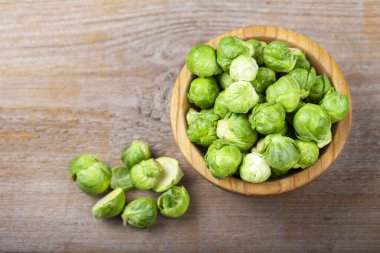 Çiğ Brüksel lahanası ahşap bir arka planda bir tabakta filizlenir. tex için yer