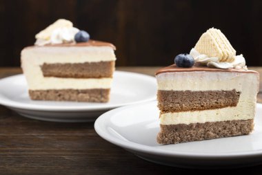 Masadaki tabakta iki dilim çikolata ya da kahveli kek. Holida için lezzetli bir ikram.